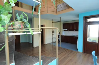 a living room with a staircase and a kitchen at Family Hotel Studio in Sandanski