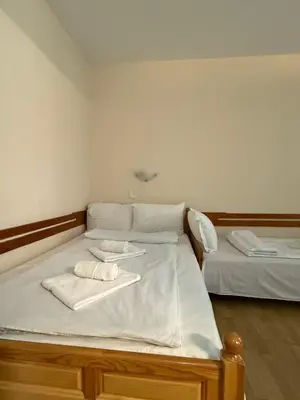 two beds in a room with towels on them at Family Hotel Studio in Sandanski