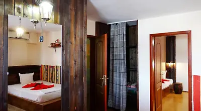 a bedroom with a bed with a red robe on it at Hotel Simona Complex in Sofia