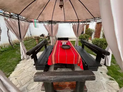 a picnic table in a tent with a red table cloth at Bayrakova Guest House in Dobrinishte