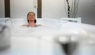a woman is sitting in a bath tub at Interhotel Sandanski in Sandanski