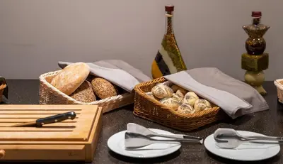 a table topped with baskets of bread and a knife at Interhotel Sandanski in Sandanski