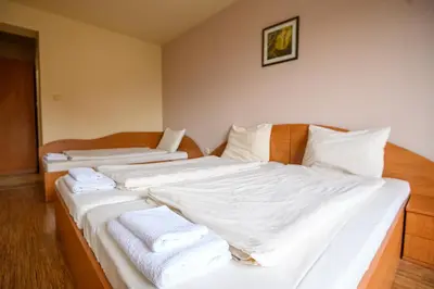 a bedroom with two beds with white sheets and towels at Hotel Saint Nicola in Banya