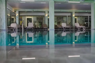 a pool with chairs in a building at Spa Hotel Orbita in Blagoevgrad