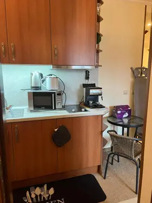 a small kitchen with a microwave and a table at Simonen Apartments near the Gondola in Bansko