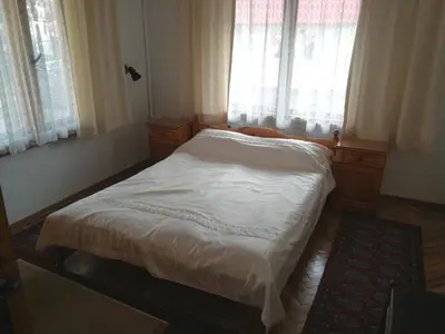a small bed in a room with two windows at Guest Rooms Metaksinovi in Chepelare