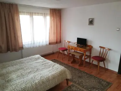 a bedroom with a bed and a desk with a computer at Guest Rooms Metaksinovi in Chepelare