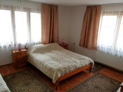 a bedroom with a bed in a room with windows at Guest Rooms Metaksinovi in Chepelare