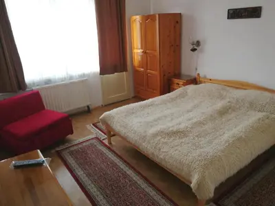 a bedroom with a bed and a red chair at Guest Rooms Metaksinovi in Chepelare