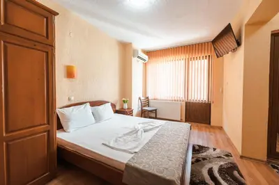 a hotel room with a bed and a window at Семеен хотел Свети Георги in Sandanski