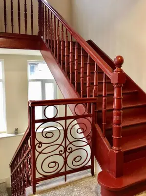 a wooden spiral staircase in a room with a window at SKYLER GUEST HOUSE in Plovdiv