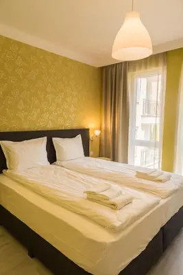 a bedroom with a large bed with white sheets and a window at Antique Residence in Hisarya