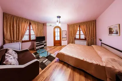 a bedroom with a large bed and a couch at Family Hotel Ogi in Asenovgrad