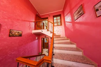 a staircase in a house with pink walls at Family Hotel Ogi in Asenovgrad