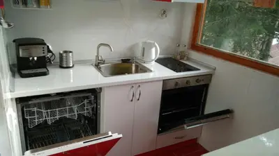 a small kitchen with a sink and a dishwasher at Къща Семково in Semkovo