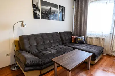 a brown couch in a living room with a table at Belvedere Holiday Club ...VIP ap. in Bansko