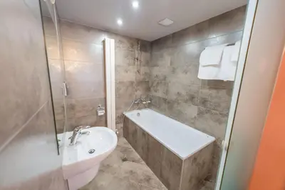 a bathroom with a tub and a sink and a toilet at Algara hut in Panichishte