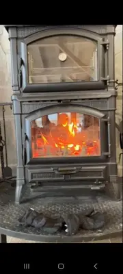a stove with a fire inside of it at Algara hut in Panichishte