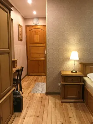 a bedroom with a bed and a desk with a lamp at Pop Bogomil family hotel in Sofia