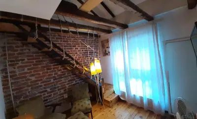 a living room with a brick wall and a window at Pop Bogomil family hotel in Sofia