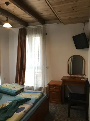 a bedroom with a bed and a mirror and a window at Pop Bogomil family hotel in Sofia
