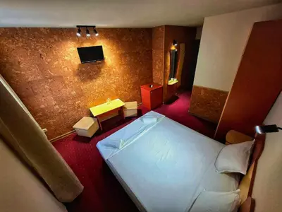 a view of a bedroom with a bed and a television at Korona Hotel in Blagoevgrad