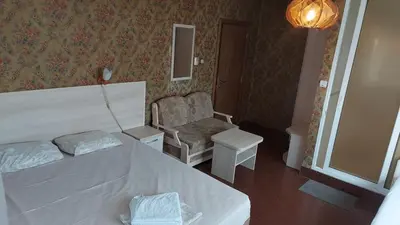 a hotel room with a bed and a chair at Family Hotel Emaly 1 in Bankya