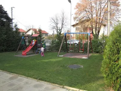 a child playing on a playground in a yard at Germanea Hotel in Sapareva Banya