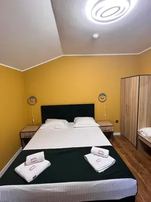 a bedroom with a large bed with towels on it at Family Hotel Emaly 2 in Sapareva Banya