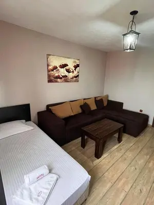 a living room with a couch and a bed at Family Hotel Emaly 2 in Sapareva Banya