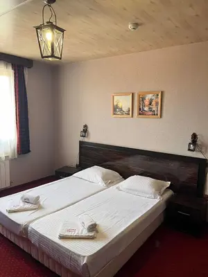 a bedroom with a large bed with two towels on it at Family Hotel Emaly 2 in Sapareva Banya