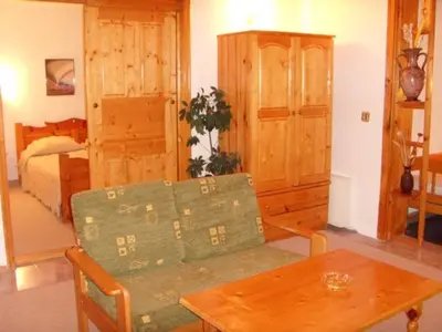 a living room with a table and a bed at Family Hotel Markony in Pamporovo