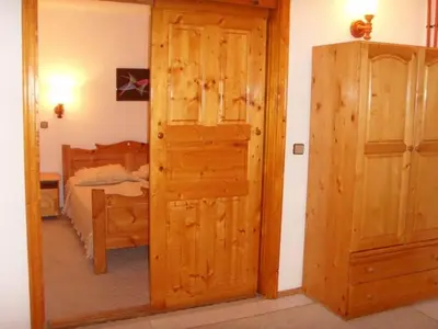 a door leading to a bedroom with a bed at Family Hotel Markony in Pamporovo