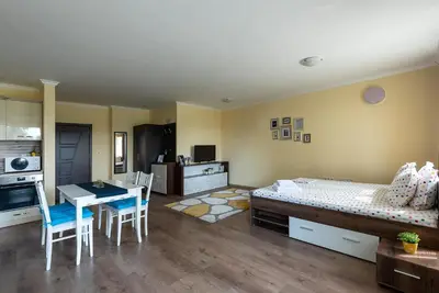 a bedroom with a bed and a table and chairs at RIVERSIDE APARTMENTS PLOVDIV with free parking in Plovdiv