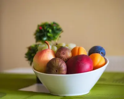 a white bowl of fruit on a table at RIVERSIDE APARTMENTS PLOVDIV with free parking in Plovdiv