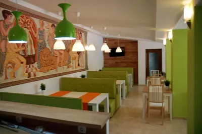 a waiting room with green chairs and a table at Green Hisar Hotel Family in Hisarya