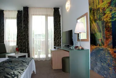 a hotel room with a bed and a television at Green Hisar Hotel Family in Hisarya