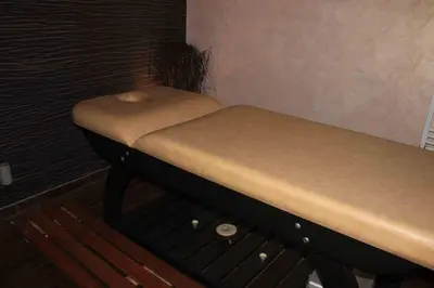 a small bed in a room with a bench at Green Hisar Hotel Family in Hisarya