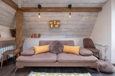 a couch in a living room with wooden walls at 2-Bedroom Elegant Apartment in Mediterranean Style in Sofia