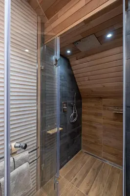 a walk in shower in a bathroom with wooden walls at 2-Bedroom Elegant Apartment in Mediterranean Style in Sofia