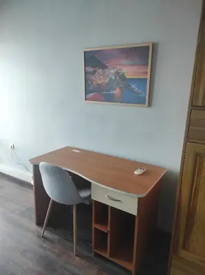 a wooden desk with a chair and a painting on the wall at Panorama Rooms in Sofia