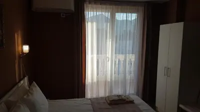 a bedroom with a bed and a large window at MARIANA - guest rooms in Gotse Delchev