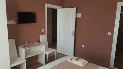 a small room with a desk and a television at MARIANA - guest rooms in Gotse Delchev