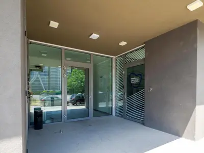 an external view of a building with glass doors at Modern Apartment with Parking next to Bulgaria Mall in Sofia