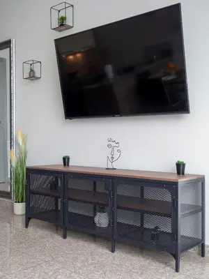 a black entertainment center with a television on a wall at Modern Apartment with Parking next to Bulgaria Mall in Sofia