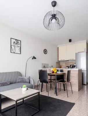 a living room with a couch and a table at Modern Apartment with Parking next to Bulgaria Mall in Sofia