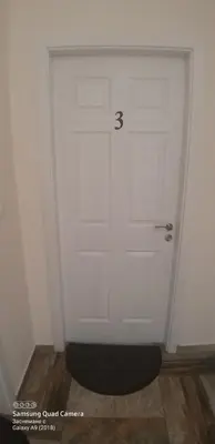 a white door with a black rug in front of it at Apartments DIEM in Samokov