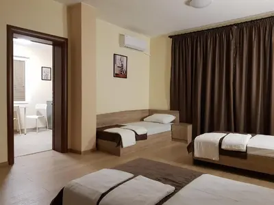 a hotel room with two beds and a window at Twain Apart&Rooms in Sofia