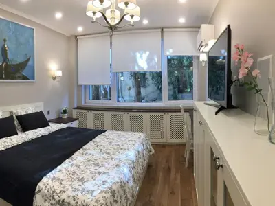 a bedroom with a bed and a desk and windows at A luxury apartment with patio and BBQ in Sofia