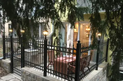 a black fence in front of a house at A luxury apartment with patio and BBQ in Sofia